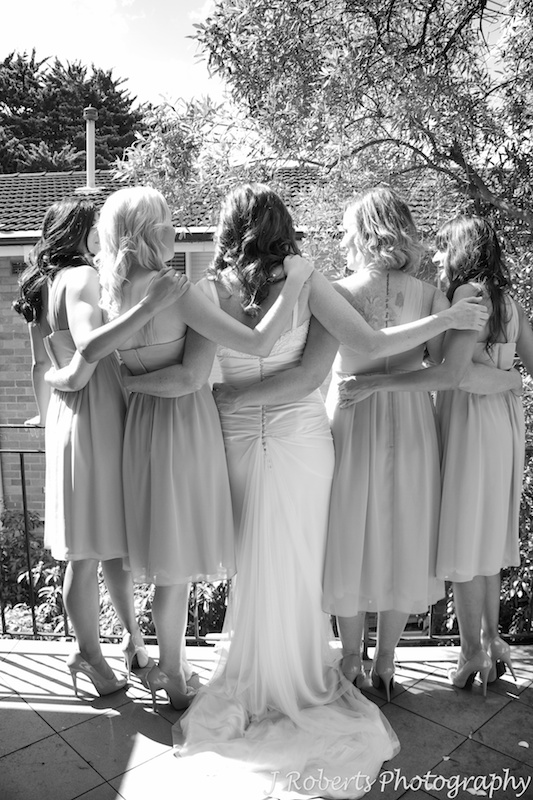 Bride and bridesmaids with their arms around each other - wedding photography sydney